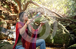 Woman performing a smudging ceremony alone in a forest