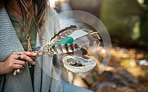 Woman performing a smudging ceremony in a forest