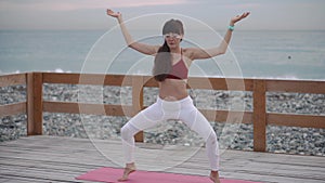 Woman is performing yoga asana, holding balance, finishing exercise