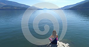 Woman performing yoga on at lake shore 4k
