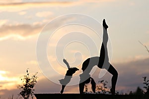 Woman performing yoga at sunset