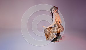 Woman performs flexible movements, twerking body on floor. Hot dance in neon