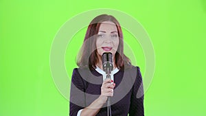 Woman performs her song of authorship. Green screen