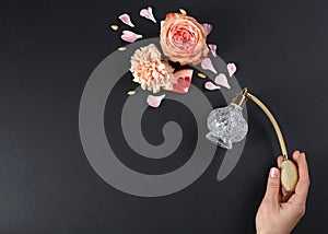 Woman with perfume. Fragrance composition, flowers and grapefruit on black background. Space for text