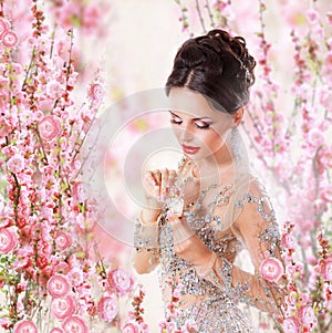 Woman with Perfume over Floral Background