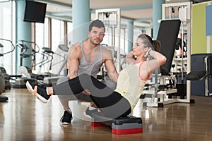 Woman With Personal Trainer On Bosu Abs Exercise