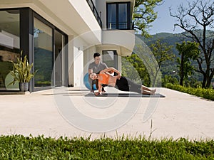 Woman with personal trainer doing morning yoga exercises