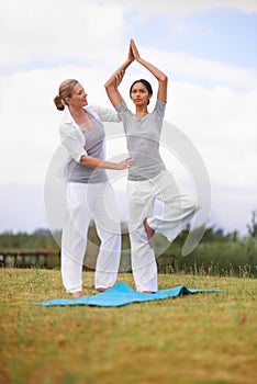 Woman, personal trainer and yoga on field in nature for spiritual wellness, namaste or wellbeing. Young female person