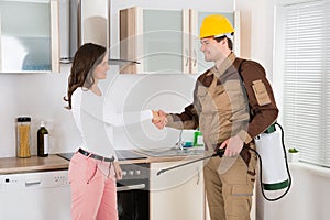 Woman And Pest Control Worker Shaking Hands