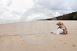 Woman and pet dog sitting on beautiful deserted beach