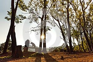 A woman pets a dog as the sun rises at Kemmangundi, Karnataka, India.