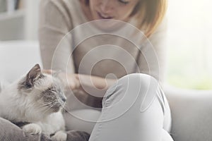 Woman petting her beautiful cat at home