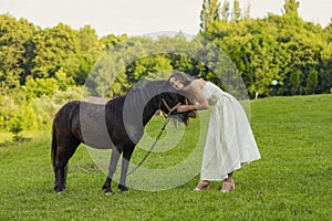 woman petting a pony