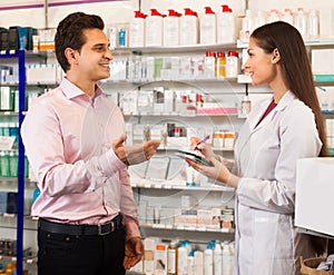 Woman pharmacist and visitor at the chemists shop