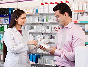 Woman pharmacist and visitor at the chemists shop