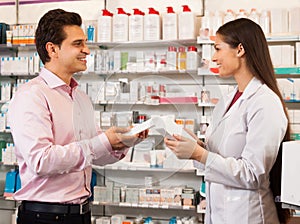 Woman pharmacist and visitor at the chemists shop