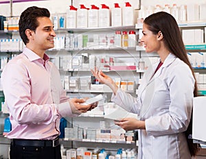 Woman pharmacist and visitor at the chemists shop