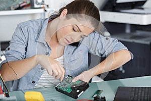 woman on phoe unscrewing back laptop