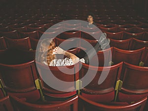 Woman on phone annoying man in auditorium