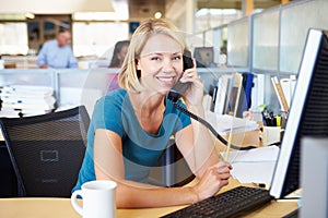 Woman On Phone In Busy Modern Office