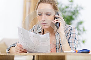 woman on phone checking design plans