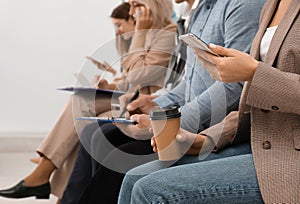 Woman with phone and cup of coffee waiting for interview in office