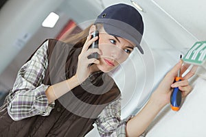 Woman on phone while fitting exit sign