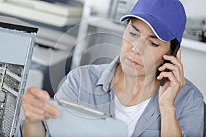 Woman on phone fixing pc