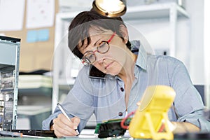 woman on phone fixing pc