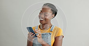 Woman, phone and laughing for chat in studio, happy and funny humor on gray background. Black female person, social