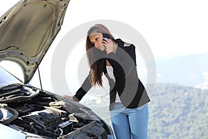 Woman on the phone looking a breakdown car