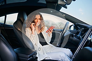 Woman with phone resting while car autopilot driving.