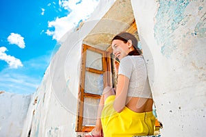 Woman with phone sitting on the window