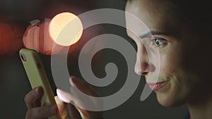 Woman phone typing, social media and night working on mobile app, reading notification and online screen in dark bokeh