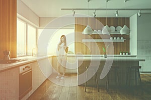 Woman with phone in wooden kitchen