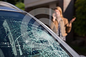 Woman Phoning For Help After Car Windshield Has Broken photo