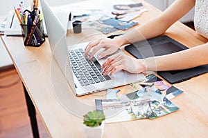 Woman photograper typing on laptop keyboard and using graphic tablet photo
