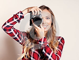 Woman photographer with camera against gray background