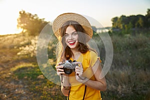 Woman photographer camera in hands smile red lips hat attractive look nature