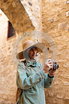 woman photographer with a camera takes pictures outdoors. A young female photographer aims the lens and enjoys the process of