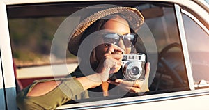 Woman, photographer and car with camera for road trip, sunset or memory on outdoor journey in nature. Female person with