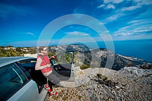 Woman photographer with car on the top of mountain