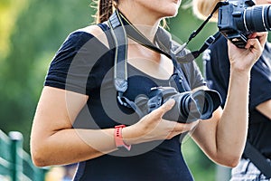 A woman photographer of European appearance on a reportage shoot. The work of a girl photographer