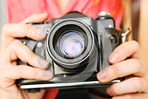 Woman photographer holding 35mm film camera.