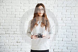 Woman photographer holding a film camera in hands