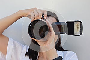 A woman photographer holds a camera in her hands and takes pictures. Close-up shot