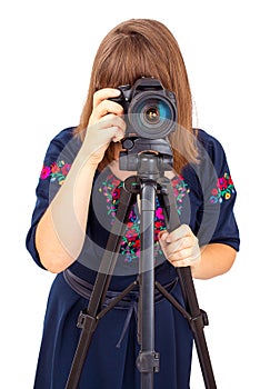 Woman photographer looking into the camera lens on a tripod