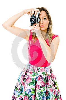 A woman photographer in magenta dress with vintage analog camera