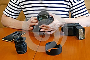 Woman photographer making her blog about photo and video camera in kitchen, lens and flash equipment, woman stocker or freelancer