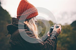 Woman photographer with photo camera shooting mountains